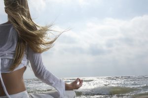 Young Woman Meditating on the Beach